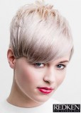 Krátký blond účes s hustou ofinou na stranu